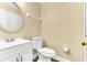 Bright bathroom featuring a white vanity and a toilet on dark wood flooring, with warm beige walls at 1631 Little Falls Cir # 92, Orlando, FL 32807
