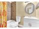 Well-lit bathroom with a shower/tub combo, decorative shower curtain, toilet, and a round mirror above the sink at 1631 Little Falls Cir # 92, Orlando, FL 32807