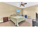 Cozy bedroom features a neutral carpet, ceiling fan, window, and a bed with a green comforter at 1631 Little Falls Cir # 92, Orlando, FL 32807