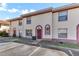 Charming townhome with a red door, cream stucco and red trim plus nicely kept front lawn area at 1631 Little Falls Cir # 92, Orlando, FL 32807