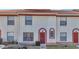 Charming townhome with a red door, cream stucco and red trim plus nicely kept front lawn area at 1631 Little Falls Cir # 92, Orlando, FL 32807