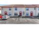 A street view of well-maintained two-story townhomes, featuring assigned parking and vibrant red doors at 1631 Little Falls Cir # 92, Orlando, FL 32807