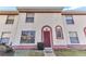 Charming townhome with a red door, cream stucco and red trim plus nicely kept front lawn area at 1631 Little Falls Cir # 92, Orlando, FL 32807