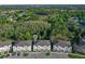Aerial view of townhomes surrounded by lush green landscape and trees, with ample parking at 17220 Blessing Dr, Clermont, FL 34714