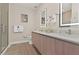 Modern bathroom featuring a double sink vanity, backlit mirrors, and a glass-enclosed shower at 17220 Blessing Dr, Clermont, FL 34714