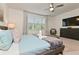 Comfortable bedroom with a ceiling fan, large window with blinds, and a dresser with a TV at 17220 Blessing Dr, Clermont, FL 34714