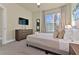 Bright bedroom with a large window, dresser with TV, and a comfortable bed with stylish pillows at 17220 Blessing Dr, Clermont, FL 34714
