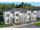 Modern townhome featuring stone accents, a neutral color scheme, and landscaped surroundings at 17220 Blessing Dr, Clermont, FL 34714