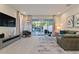 Open-concept living room with a large TV, comfortable sofa, and sliding glass doors to the patio at 17220 Blessing Dr, Clermont, FL 34714