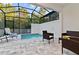 Enjoy the screened-in outdoor pool area featuring stylish patio furniture and lush green surroundings at 17220 Blessing Dr, Clermont, FL 34714