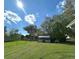 Expansive backyard showcasing a white shed surrounded by lush green grass and mature trees at 224 Montana Ave, St Cloud, FL 34769
