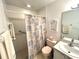 Small bathroom with colorful shower curtain, vanity, toilet, and a tile shower at 224 Montana Ave, St Cloud, FL 34769