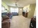 Cozy living room featuring a ceiling fan, plush seating, and abundant natural light through the window at 224 Montana Ave, St Cloud, FL 34769