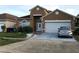 Two-story home boasts an attached garage and simple landscaping at 2244 Mallard Creek Cir, Kissimmee, FL 34743