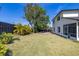 Manicured backyard boasting vibrant landscaping, green grass, and a stone patio area for relaxation at 2313 Duncan Trl, Clermont, FL 34714