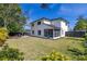 Expansive backyard featuring lush green lawn, privacy fence, screened lanai and mature trees at 2313 Duncan Trl, Clermont, FL 34714