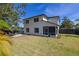 Lush backyard showcasing green lawn, privacy fence, tropical plants, and a stone patio at 2313 Duncan Trl, Clermont, FL 34714