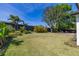 Expansive backyard featuring lush green lawn, mature trees, and a stone patio area at 2313 Duncan Trl, Clermont, FL 34714