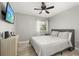 Comfortable bedroom featuring light hardwood floors, a ceiling fan, and a flat screen television at 2313 Duncan Trl, Clermont, FL 34714