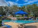 Well-maintained community pool area featuring umbrellas, tables, and plenty of seating at 2313 Duncan Trl, Clermont, FL 34714