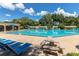 Resort-style pool with comfortable seating under blue umbrellas, perfect for relaxation and recreation at 2313 Duncan Trl, Clermont, FL 34714