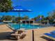 Community pool with clear blue water, lots of umbrellas and seating for relaxing in the shade at 2313 Duncan Trl, Clermont, FL 34714