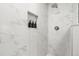 This bright white shower features beautiful marble tile and built-in shelving with hexagon tile accents at 2313 Duncan Trl, Clermont, FL 34714