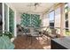 Relaxing sunroom with hammock, chairs, and decorative tropical curtains at 2313 Duncan Trl, Clermont, FL 34714