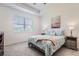 Cozy bedroom with a floral-themed bedspread, carpeted floors, a window with blinds, and side tables at 2372 Sirena Ln, Mount Dora, FL 32757