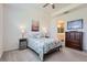 Comfortable bedroom with floral bedding, carpet, and side tables, with a bathroom and dresser nearby at 2372 Sirena Ln, Mount Dora, FL 32757
