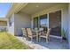 Relaxing outdoor patio with dining table and chairs, with view through sliding glass door at 2372 Sirena Ln, Mount Dora, FL 32757