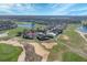 Stunning aerial view of the property with a tile roof on a golf course with a sand trap and pond at 2375 Pinehurst Ct, Davenport, FL 33837