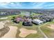 Stunning aerial view of the property with a tile roof on a golf course with a sand trap and pond at 2375 Pinehurst Ct, Davenport, FL 33837