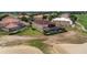 An aerial view of a tan two-story home with a screened-in pool and tile roof overlooking a golf course at 2375 Pinehurst Ct, Davenport, FL 33837
