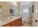 Well-lit bathroom with double vanity, a large mirror, tiled floors, and shower-tub combination at 2375 Pinehurst Ct, Davenport, FL 33837