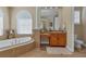Bright bathroom with a soaking tub, granite countertops, and ample vanity space at 2375 Pinehurst Ct, Davenport, FL 33837