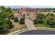 Elegant two-story home with well-manicured lawn, brick driveway, arched window, and a red tile roof at 2375 Pinehurst Ct, Davenport, FL 33837