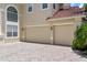 A long brick driveway going up to the two-car garage of a light brown house at 2375 Pinehurst Ct, Davenport, FL 33837