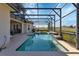 Inviting screened-in pool area with a sparkling pool, spa, and views of the lush green golf course at 2375 Pinehurst Ct, Davenport, FL 33837