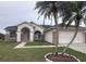 Charming single-story home featuring a well-manicured lawn, brick accents, and mature palm trees at 2438 Winfield Dr, Kissimmee, FL 34743