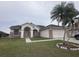Charming single-story home featuring a well-manicured lawn, brick accents, and mature palm trees at 2438 Winfield Dr, Kissimmee, FL 34743