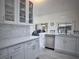 Bright kitchen with white cabinetry, tiled backsplash, and stainless steel dishwasher and faucet at 2438 Winfield Dr, Kissimmee, FL 34743