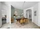 Dining area with seating for six, next to an open hallway and a decorative shelf with plants and picture frames at 2539 Jasmine Trace Dr, Kissimmee, FL 34758