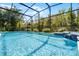 Sparkling screened-in pool with waterfall feature, perfect for relaxation and outdoor enjoyment at 2539 Jasmine Trace Dr, Kissimmee, FL 34758