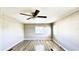 Bedroom with light wood-look floors, ceiling fan, and a window at 2601 Salina Way, Kissimmee, FL 34758