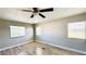 Bedroom with light wood-look floors, three windows, and neutral walls at 2601 Salina Way, Kissimmee, FL 34758