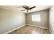 Bedroom with light wood-look floors, ceiling fan, and window at 2601 Salina Way, Kissimmee, FL 34758