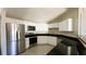 Modern kitchen featuring stainless steel appliances, white cabinets, and black countertops at 2601 Salina Way, Kissimmee, FL 34758