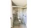 Bathroom shower featuring tiled walls, pebble floor, and glass doors at 2601 Salina Way, Kissimmee, FL 34758