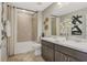 Neutral bathroom features a double sink vanity, bathtub with shower, and decorative accents at 276 Hilltop Bloom Loop, Haines City, FL 33844